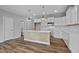 Open kitchen with white cabinets, center island with light wood accent, and stainless appliances at 703 Jamescroft Way, Rolesville, NC 27587
