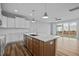 Bright kitchen with white cabinets, wood-look island, stainless appliances, and access to the backyard at 703 Jamescroft Way, Rolesville, NC 27587