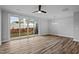 Living room with wood-look flooring, ceiling fan, light fixture, and backyard access at 703 Jamescroft Way, Rolesville, NC 27587