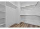 Spacious walk-in closet with shelving and wood rods for hanging clothes at 703 Jamescroft Way, Rolesville, NC 27587