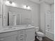 A modern bathroom featuring double sink vanity, large mirror, and bathtub-shower combination at 707 Jamescroft Way, Rolesville, NC 27587