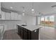 Open kitchen featuring white cabinets, island with sink and stainless steel appliances, flowing into the living area at 707 Jamescroft Way, Rolesville, NC 27587