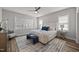 Bright bedroom featuring a large bed, wood-look flooring, large windows, and stylish furnishings at 709 Jamescroft Way, Rolesville, NC 27587