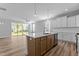 Open kitchen with island featuring quartz countertop, stainless sink, and wood cabinets at 709 Jamescroft Way, Rolesville, NC 27587