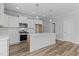 Modern kitchen boasts white cabinets, quartz countertops, stainless appliances, and wood-look floors at 709 Jamescroft Way, Rolesville, NC 27587