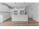 Modern kitchen boasts white cabinets, quartz countertops, stainless appliances, and wood-look floors at 709 Jamescroft Way, Rolesville, NC 27587