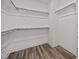 Empty walk-in closet featuring wooden racks and wood-look flooring at 709 Jamescroft Way, Rolesville, NC 27587
