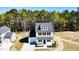 Aerial view of a modern farmhouse featuring a well-manicured lawn and proximity to a lush forest at 806 Roberts Rd, Sanford, NC 27332