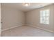 This is a carpeted bedroom with a window offering a view of the trees outside at 806 Roberts Rd, Sanford, NC 27332