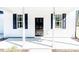 Close-up of the front porch with white columns and a black front door at 806 Roberts Rd, Sanford, NC 27332