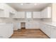 Well-lit kitchen featuring stylish white cabinets, counters, and stainless steel hardware, all on wood-look floors at 806 Roberts Rd, Sanford, NC 27332