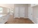 Open living room with wood-look floors connecting to the kitchen, illuminated by natural light from nearby windows at 806 Roberts Rd, Sanford, NC 27332