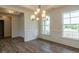 Elegant dining room with wainscoting, stylish chandelier, and ample natural light at 8305 Cannon Grove Dr, Willow Springs, NC 27592