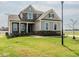 Charming two-story home featuring a mix of stone and siding, a covered porch, and well-manicured lawn at 8305 Cannon Grove Dr, Willow Springs, NC 27592