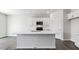 Modern kitchen features white cabinets, stainless steel appliances, and a large center island at 98 Ethel Ln, Angier, NC 27501