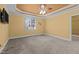 Bedroom featuring carpeted floors, a tray ceiling with fan, and a large window at 319 Fox Hollow Dr, Clayton, NC 27527