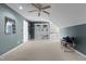Carpeted bonus room with a ceiling fan, built-in shelves, and view to the stairway at 319 Fox Hollow Dr, Clayton, NC 27527