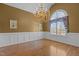 A formal dining room featuring a chandelier, chair-rail molding, hard wood floor, and large windows at 319 Fox Hollow Dr, Clayton, NC 27527