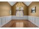 Elegant dining room with hardwood floors, classic wainscoting, and a stunning chandelier fixture at 319 Fox Hollow Dr, Clayton, NC 27527