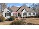 White two-story house with a brown roof, landscaping, and a large front yard at 319 Fox Hollow Dr, Clayton, NC 27527