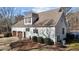 An eye-level view of the home's exterior, featuring a garage, a dormer window, and manicured landscaping at 319 Fox Hollow Dr, Clayton, NC 27527