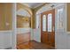 A foyer featuring a decorative glass door with side-lights, a chandelier, columns, and hardwood flooring at 319 Fox Hollow Dr, Clayton, NC 27527