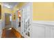 Hallway features hardwood floors, white wainscoting, and a glass door leading to the carpeted stairs at 319 Fox Hollow Dr, Clayton, NC 27527