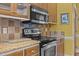 Modern kitchen featuring stainless steel oven, microwave, granite countertops and wooden cabinets at 319 Fox Hollow Dr, Clayton, NC 27527