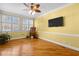 Sunny living room with hardwood floors, large windows, and a ceiling fan for maximum comfort at 319 Fox Hollow Dr, Clayton, NC 27527