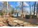 Cozy outbuilding with a teal door and mature trees on a sunny lot at 319 Fox Hollow Dr, Clayton, NC 27527