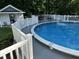 An above ground pool with a deck and a small white pool house nearby at 319 Fox Hollow Dr, Clayton, NC 27527