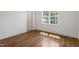 Bedroom with hardwood floors and window showcasing natural light and backyard views at 3302.5 Hall Pl, Raleigh, NC 27607