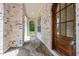 View of the front porch, featuring brick siding, stone floors, an arched entryway, and a wooden door at 3302.5 Hall Pl, Raleigh, NC 27607