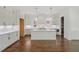 Bright kitchen featuring white cabinets, an island with sink, pendant lighting, and hardwood floors at 3302.5 Hall Pl, Raleigh, NC 27607