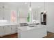Bright kitchen featuring white cabinets, an island with sink, pendant lighting, and hardwood floors at 3302.5 Hall Pl, Raleigh, NC 27607
