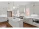 Bright kitchen featuring white cabinets, an island with sink, pendant lighting, and stainless appliances at 3302.5 Hall Pl, Raleigh, NC 27607