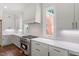 Bright, modern kitchen features stainless steel appliances, white cabinets, and subway tile backsplash at 3302.5 Hall Pl, Raleigh, NC 27607