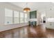 Bright living room featuring hardwood floors, large windows, and transition to kitchen with custom cabinets at 3302.5 Hall Pl, Raleigh, NC 27607