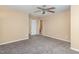 Spacious carpeted bedroom featuring neutral walls, ceiling fan, and multiple doorways at 3417 Cardinal Lake Dr, Durham, NC 27704