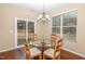 A dining room featuring a glass table, seating for four, and a sliding glass door at 3417 Cardinal Lake Dr, Durham, NC 27704
