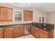 Well-lit kitchen with stainless steel dishwasher, granite countertops, and wood cabinetry at 3417 Cardinal Lake Dr, Durham, NC 27704