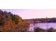 Scenic lake view surrounded by lush trees with vibrant fall foliage on a sunny day at 3417 Cardinal Lake Dr, Durham, NC 27704