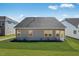 Well-maintained backyard showcasing fresh landscaping, a gray exterior, and a neatly manicured lawn at 800 Heathered Farm Way, Apex, NC 27523