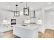 Modern kitchen with white cabinets, stainless steel appliances, an island, and stylish pendant lights at 800 Heathered Farm Way, Apex, NC 27523