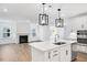 Open-concept kitchen featuring an island, stainless steel appliances, and modern pendant lighting at 800 Heathered Farm Way, Apex, NC 27523