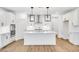 Stylish kitchen boasts an island, stainless steel appliances, and sleek white cabinetry at 800 Heathered Farm Way, Apex, NC 27523