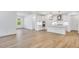 Open kitchen design with an island, white cabinetry, stainless appliances, and wood flooring at 800 Heathered Farm Way, Apex, NC 27523