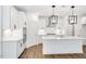 Bright kitchen featuring an island, stainless steel appliances, white cabinets, and modern lighting fixtures at 800 Heathered Farm Way, Apex, NC 27523