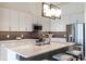 Open-concept kitchen with sleek stainless steel appliances, modern cabinetry, and gray backsplash at 120 Mosaic Blvd # 307, Pittsboro, NC 27312