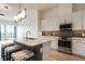 Stylish kitchen featuring an island with bar seating, stainless steel appliances, and contemporary lighting at 120 Mosaic Blvd # 307, Pittsboro, NC 27312